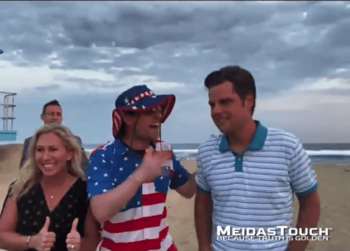 Gaetz, Greene poses with a man who appears to be a prankster for beach photo op.